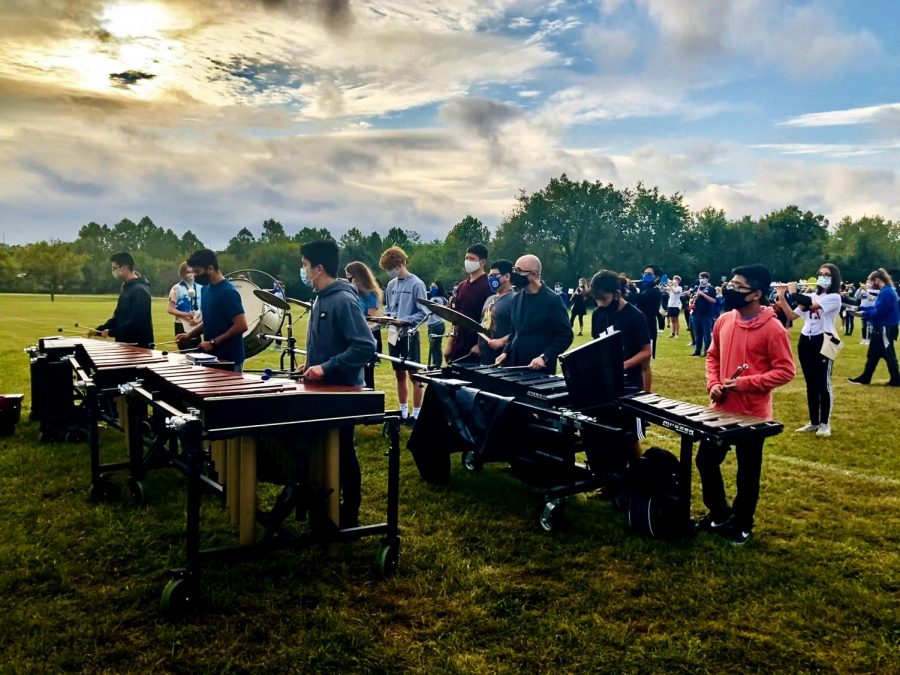 George Vera, band director at Elmwood Middle School, performs with the rest of the front ensemble on their halftime show.