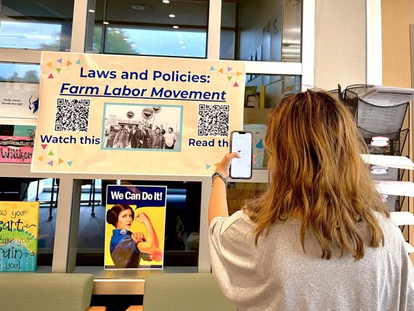 As a part of Hispanic Heritage Month events in the Library, Ruby Hernandez, 12, scans a QR code to learn more about the Farm Labor Movement.
Photo | Adelyn Wright